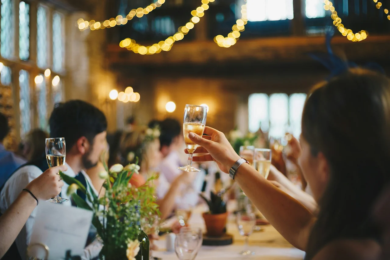 Special Event Websites - Bride's arm holding a glass of champagne in the air at reception